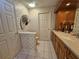 Bathroom featuring classic vanity, cabinet, and tiled walls with decorative hand fan at 2210 Bayou Dr, Holiday, FL 34691