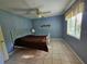 Cozy bedroom with a metal frame bed, ceiling fan, and a bright window at 2210 Bayou Dr, Holiday, FL 34691