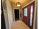 Inviting entryway with a decorative front door, ample storage, and neutral tile flooring at 2210 Bayou Dr, Holiday, FL 34691