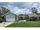 Charming single-story home with a well-maintained lawn and a two-car garage, with landscaping at 2210 Bayou Dr, Holiday, FL 34691