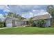 Charming single-story home featuring a well-manicured lawn, palm trees, and a two-car garage at 2210 Bayou Dr, Holiday, FL 34691