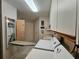 Functional laundry room featuring a pull-down ironing board and essential appliances at 2210 Bayou Dr, Holiday, FL 34691