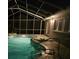 Enclosed pool with elegant lighting, integrated stairs, and easy access to house at 2210 Bayou Dr, Holiday, FL 34691