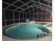 A tranquil screened-in pool at night, with subtle lighting enhancing the water's gentle glow at 2210 Bayou Dr, Holiday, FL 34691