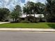 Charming exterior of the home with a stone facade, lush landscaping, and well-maintained lawn at 2215 Toniwood Ln, Palm Harbor, FL 34685