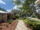 Beautifully landscaped front yard with a stone walkway leading to the charming stone facade entrance at 2215 Toniwood Ln, Palm Harbor, FL 34685