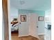 Bright hallway leading to a bedroom with ensuite bath, featuring light walls and wood-look flooring at 2215 Toniwood Ln, Palm Harbor, FL 34685