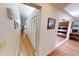 Hallway with multiple closets leading to the kitchen, featuring neutral walls and wood-look flooring at 2215 Toniwood Ln, Palm Harbor, FL 34685