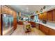 Spacious kitchen featuring hardwood floors, wooden cabinets, stainless steel appliances, and a central island at 2215 Toniwood Ln, Palm Harbor, FL 34685