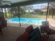 Screened patio seating area overlooks sparkling pool at 2215 Toniwood Ln, Palm Harbor, FL 34685