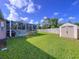 Large backyard featuring a pool, screen enclosure, and storage shed at 22804 Willow Lakes Dr, Lutz, FL 33549