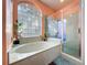 A well lit bathroom with a separate shower and a tub beneath a glass block window at 22804 Willow Lakes Dr, Lutz, FL 33549