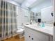 Bathroom featuring a shower-tub combo, white vanity, modern fixtures and wood look flooring at 22804 Willow Lakes Dr, Lutz, FL 33549