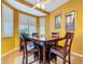 A dining area has a square table, four chairs, shutters on the windows and two wall paintings at 22804 Willow Lakes Dr, Lutz, FL 33549