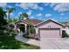 Charming one-story home featuring a well-manicured lawn, a two-car garage and mature landscaping at 22804 Willow Lakes Dr, Lutz, FL 33549
