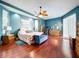 A spacious main bedroom with wood floors, ceiling fan and a bench at the foot of the bed at 22804 Willow Lakes Dr, Lutz, FL 33549