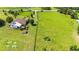 Scenic view of the property showcasing the home, swimming pool, and spacious lawn enclosed by fencing and lush greenery at 23075 Hayman Rd, Brooksville, FL 34602