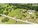 High-angle aerial view of the property showcasing the home, surrounding greenery, and generous land extending beyond the residence at 23075 Hayman Rd, Brooksville, FL 34602