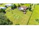 Overhead aerial perspective of the property emphasizing the house, screened-in pool, neat landscaping, and extensive yard space at 23075 Hayman Rd, Brooksville, FL 34602
