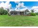 Backyard featuring a screened in patio and an additional patio area with landscaping at 23075 Hayman Rd, Brooksville, FL 34602