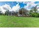 Expansive backyard view highlighting covered patio, outdoor grill, and screened-in pool at 23075 Hayman Rd, Brooksville, FL 34602