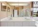 This bathroom features a vanity with double sinks, large mirrors, and a frameless glass enclosed shower at 23075 Hayman Rd, Brooksville, FL 34602