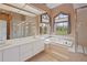 Bright bathroom featuring soaking tub, double sinks and frameless glass enclosed shower at 23075 Hayman Rd, Brooksville, FL 34602