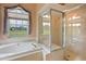 Bright bathroom with soaking tub and glass enclosed shower offering views of the property at 23075 Hayman Rd, Brooksville, FL 34602