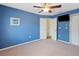 Bedroom with blue walls, ceiling fan, and closet at 23075 Hayman Rd, Brooksville, FL 34602