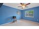 Bedroom with blue walls, ceiling fan, and natural light from the window at 23075 Hayman Rd, Brooksville, FL 34602