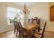 Elegant dining room featuring a chandelier, wooden table and chairs, and natural light from the large window at 23075 Hayman Rd, Brooksville, FL 34602
