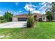 Charming home featuring a large garage, mature trees, and a well-manicured lawn at 23075 Hayman Rd, Brooksville, FL 34602