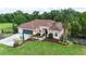 Beautiful home exterior with a well-manicured lawn, large driveway, screened garage, and lush landscaping at 23075 Hayman Rd, Brooksville, FL 34602