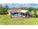 Exterior view of the home featuring a screened-in pool and outdoor seating area for relaxation and entertainment at 23075 Hayman Rd, Brooksville, FL 34602