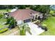 Beautiful home exterior with a well-manicured lawn, large driveway, screened garage, and lush landscaping at 23075 Hayman Rd, Brooksville, FL 34602