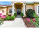 Inviting front entryway featuring a decorative door, columns, and lush landscaping at 23075 Hayman Rd, Brooksville, FL 34602