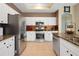 Well-equipped kitchen featuring stainless steel appliances, white cabinets, granite countertops, and tile backsplash at 23075 Hayman Rd, Brooksville, FL 34602