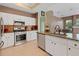 Open kitchen featuring stainless steel appliances, granite countertops, and modern white cabinetry at 23075 Hayman Rd, Brooksville, FL 34602