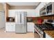 Modern kitchen featuring stainless steel appliances, white cabinets, and granite countertops at 23075 Hayman Rd, Brooksville, FL 34602