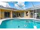 Exterior view of blue swimming pool in screened-in lanai and covered porch at 23075 Hayman Rd, Brooksville, FL 34602