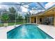 Clear blue pool surrounded by screened enclosure and stucco exterior at 23075 Hayman Rd, Brooksville, FL 34602