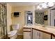 Well-lit bathroom with a vanity, mirror, toilet, and tiled flooring at 2333 Feather Sound Drive # A409, Clearwater, FL 33762