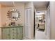 Hallway features decorative cabinet, mirror, and glimpse into the bathroom at 2333 Feather Sound Drive # A409, Clearwater, FL 33762