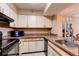 Well-lit kitchen with white cabinetry, neutral countertops, and essential appliances at 2333 Feather Sound Drive # A409, Clearwater, FL 33762