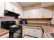 Bright kitchen with white cabinets, black appliances, and speckled countertops at 2333 Feather Sound Drive # A409, Clearwater, FL 33762