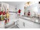 Bright bathroom with granite vanity, floral shower curtain, and modern lighting at 2430 Florentine Way # 40, Clearwater, FL 33763