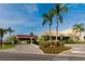 Clubhouse entrance with palm trees, landscaped areas, and a covered entryway creates a welcoming atmosphere at 2430 Florentine Way # 40, Clearwater, FL 33763
