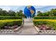 A large globe-shaped sculpture is set amidst flowering bushes, creating an inviting community centerpiece at 2430 Florentine Way # 40, Clearwater, FL 33763