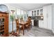 Dining area with wood table, chairs, window shutters, and white cabinets with wine cooler at 2430 Florentine Way # 40, Clearwater, FL 33763