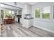 Open dining area with white cabinetry, shutters, wood-look floors, and view to a dining table at 2430 Florentine Way # 40, Clearwater, FL 33763